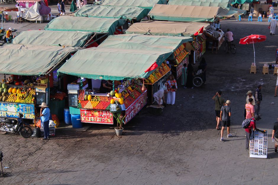 Colorful Moroccan souk stalls in Marrakech bustling with local vendors and fresh produce.